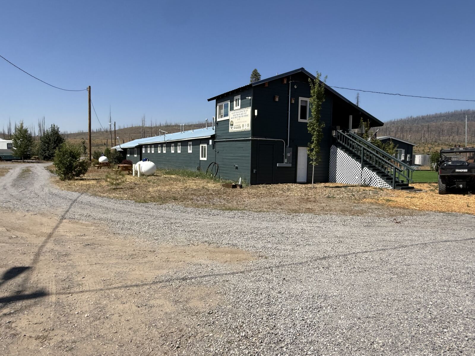 The gravel drive curving in past the two storey end of the motel at Cedar Lodge.